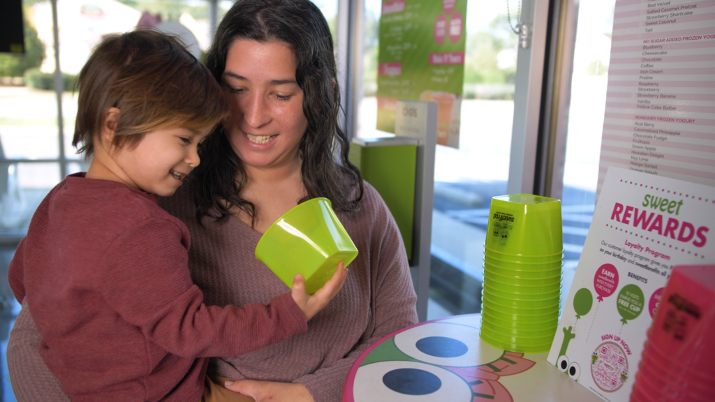 customers select a frozen yogurt cup with smiling faces