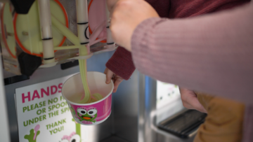 Frozen yogurt is being dispensed into a cup